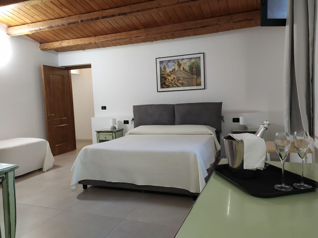 Room at Villa Scaduto hotel with double bed and wooden beams